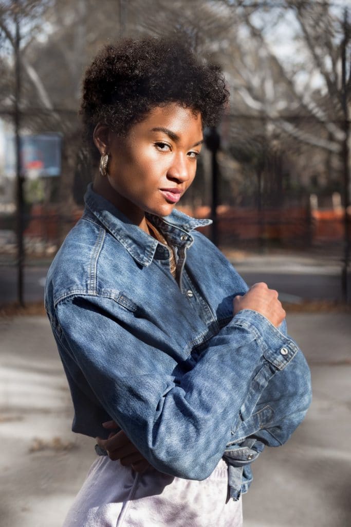 Femme avec une coupe courte tendance, cheveux bouclés et noirs