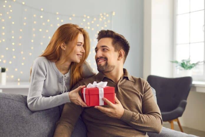 femme qui offre un cadeau à son homme pour Noël